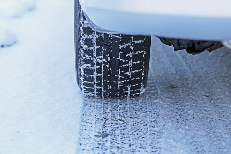 雪道を走行するスタッドレスタイヤを履いた車両