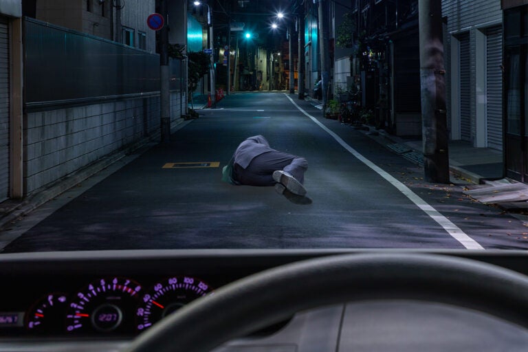 道路で寝そべっている人