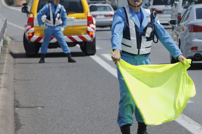 旗を振っている高速道路の交通管理隊員