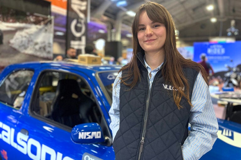 自動車誌『ヴュルカン』のスタッフ、ヴァランティンヌさんは24歳。同僚たちと展示した「日産ミクラ（日本名マーチ）」の前で。