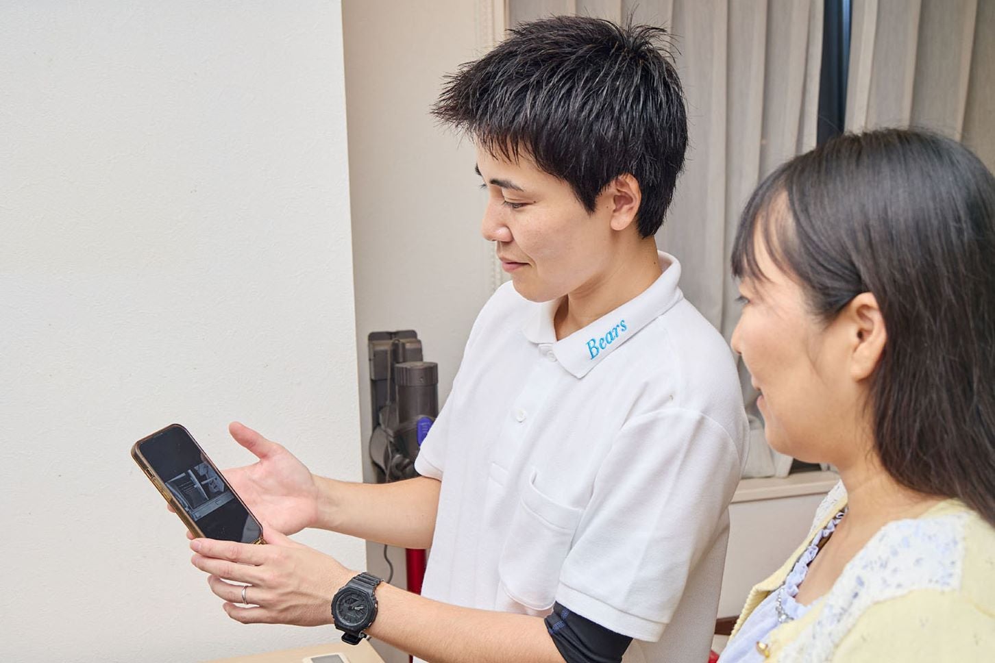 清掃員より説明を受ける女性