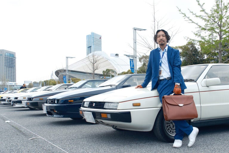 幕張メッセの駐車場には20台近くのピアッツァがズラリと並んだ。後藤氏もこの日のためにコーディネイト。実は手持ちのバッグもジウジアーロデザインだ。