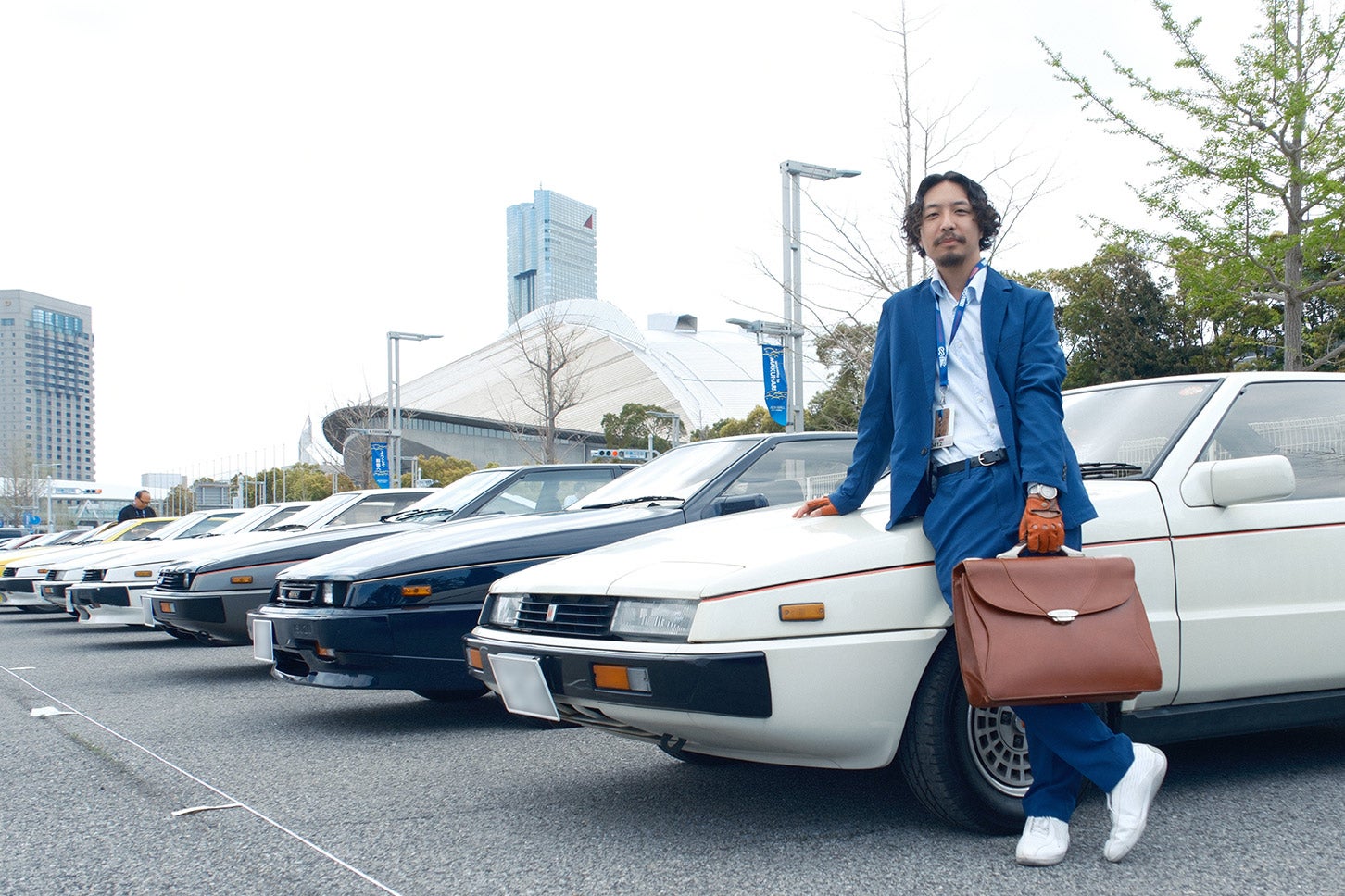 幕張メッセの駐車場には20台近くのピアッツァがズラリと並んだ。後藤氏もこの日のためにコーディネイト。実は手持ちのバッグもジウジアーロデザインだ。