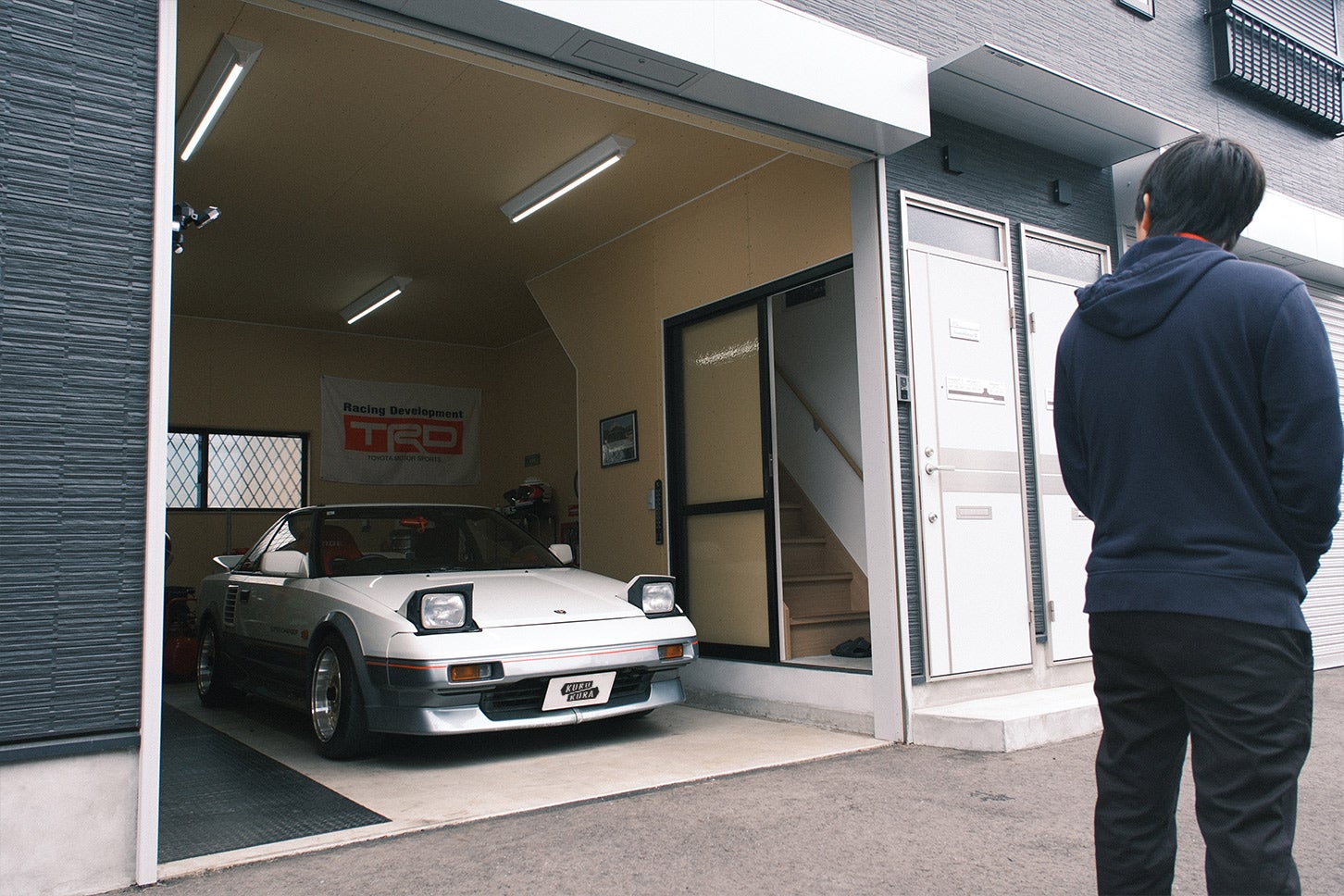 こちらの賃貸ガレージハウスは「Freedom Garage(フリーダムガレージ)」というシリーズ。床はコンクリート土間仕上げで、壁は石膏ボードが剥き出しの無骨さが良い感じ。1階がガレージで、階段で昇った2階が居住スペースとなっている。