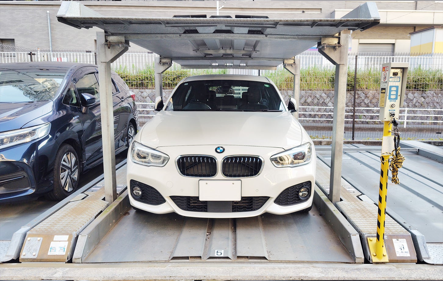 愛車のBMW1シリーズを機械式駐車場に停めた様子。窮屈な状態であることが伝わるだろうか？