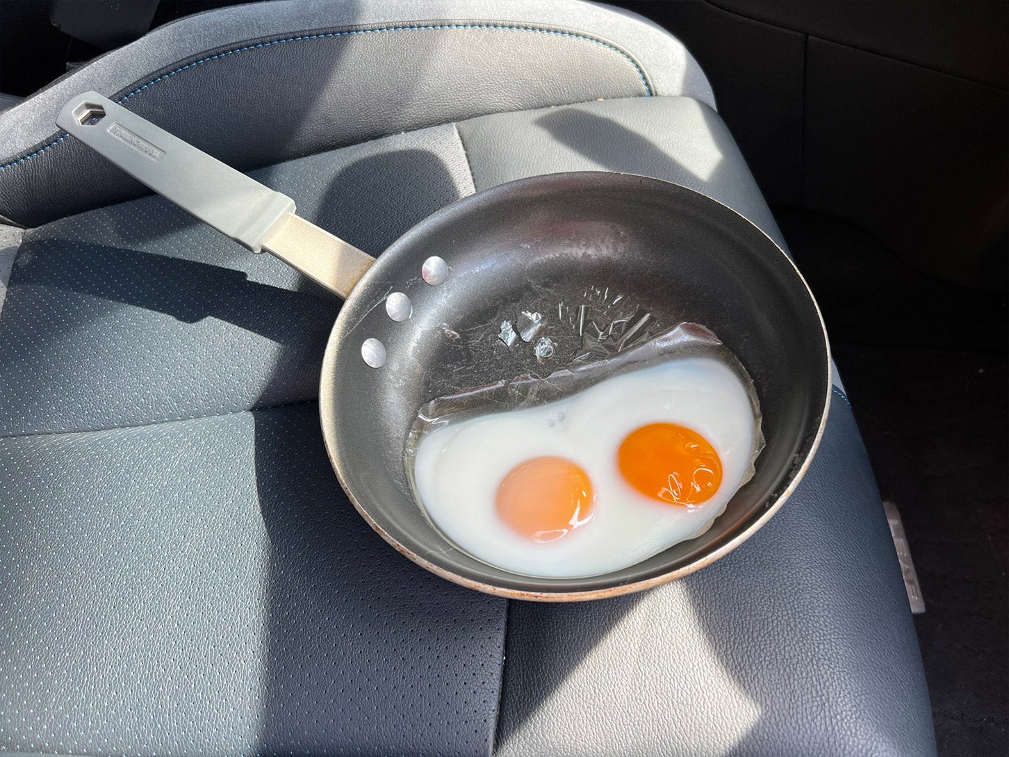 車内のダッシュボード上で卵を放置すると、目玉焼きができた。ボンネット上はもちろん、日差しが当たる車内だってこんなにも危険だ。