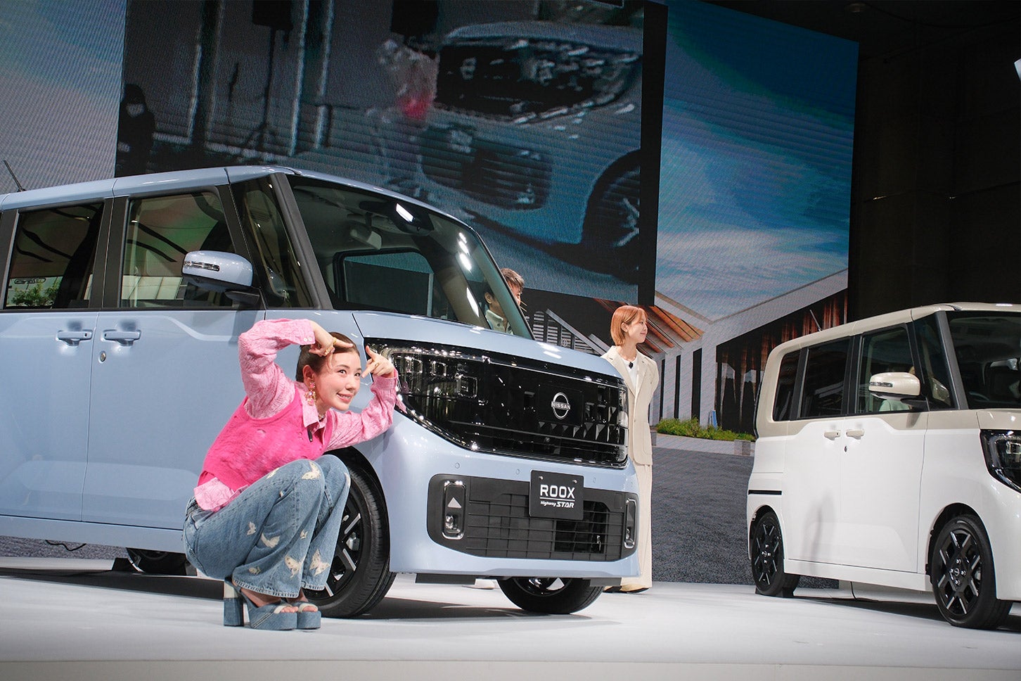 日産新型ルークス発表会では、CMキャラクターの仲里依紗さんが登場。写真右 白のルークスの運転席から死角となる場所に隠れても、インテリジェントアラウンドビューモニター機能を通して仲さんの姿を確認できる実演デモも実施された。