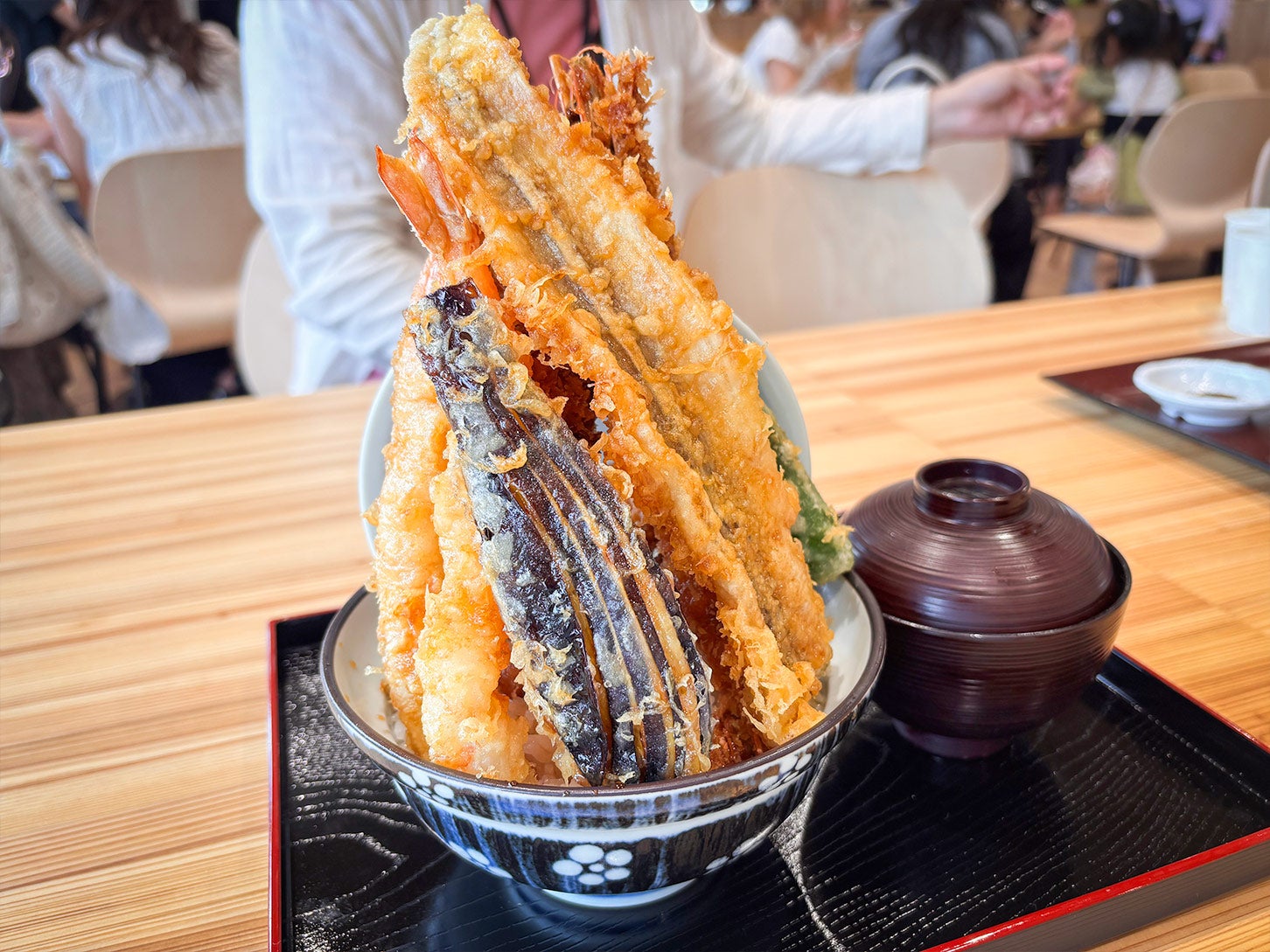 海幸一番さんが提供するマチテラス日進限定メニューの「タワー天丼」がこちら！ 海鮮や季節野菜の天ぷらに加え、タワーを支える中心には唐揚げが入って大ボリュームです！
