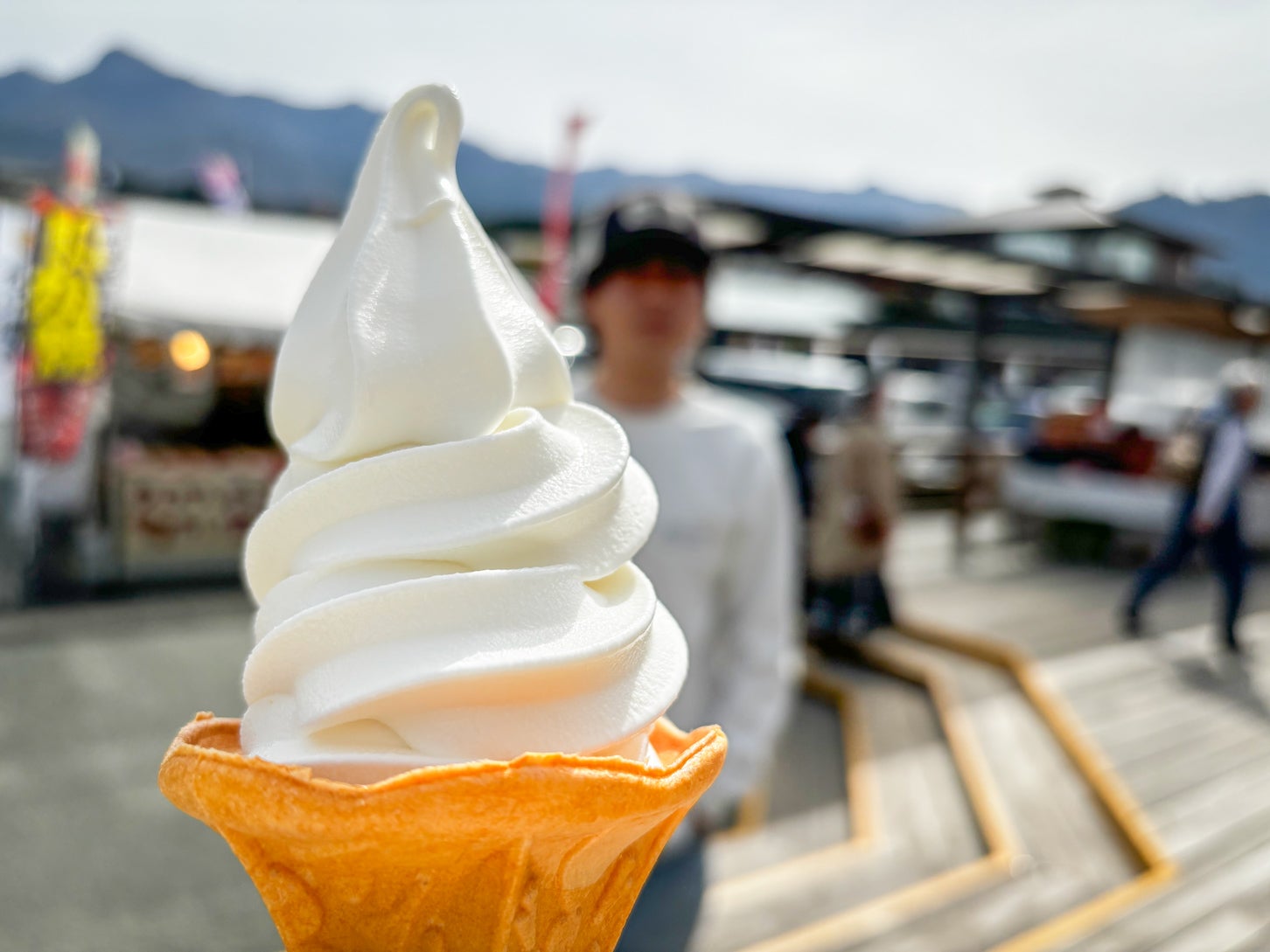 夏といえばソフトクリーム！ 奥にボヤけて映っているのは相方のだんぺいです（笑）。