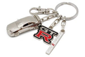 スカイラインGT-Rのチャームとロゴチャーム、シリアルナンバー入りプレートの3つで構成されている。