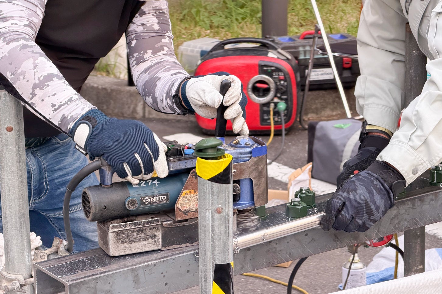 鋼構造物の亀裂が広がるのを防ぐために穴を開け、ボルトで補強する作業のデモンストレーション。高速道路の点検・補修には、作業員の手に頼らざるをえない作業が多数ある。「首都高点検・補修デモ2025」で筆者撮影
