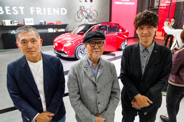 ジャパンモビリティショー2025の最後の一枚は、「僕にとって今回のベスト・デザインかも」と吉田 匠が唸ったマツダ・ビジョン クロスコンパクトを背景に、デザイン本部長の木元英二さんと一緒に