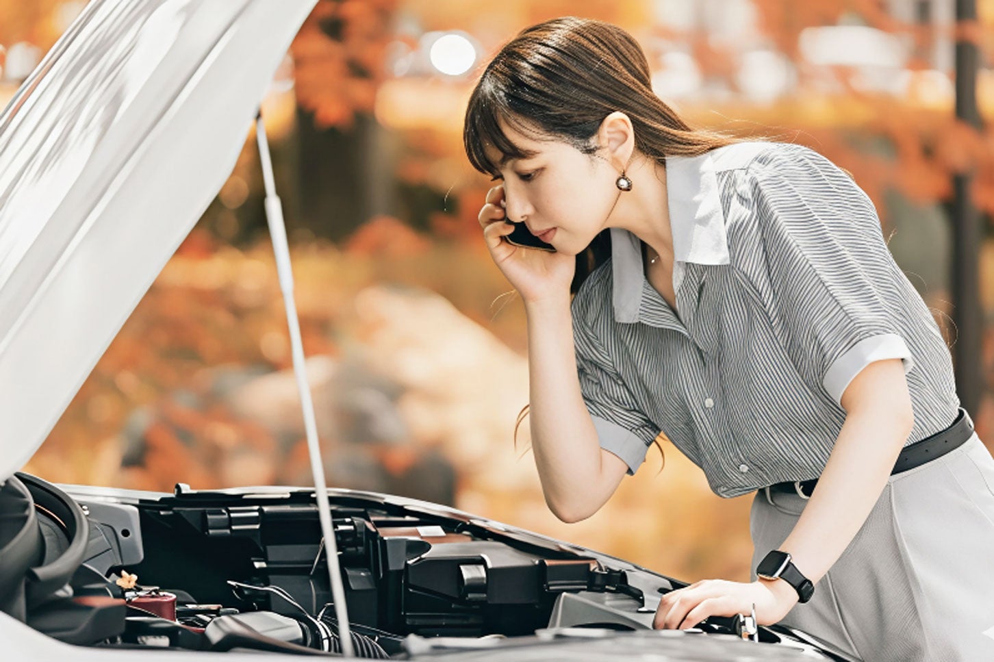 クルマの点検をする女性。(c)Trickster – stock.adobe.com