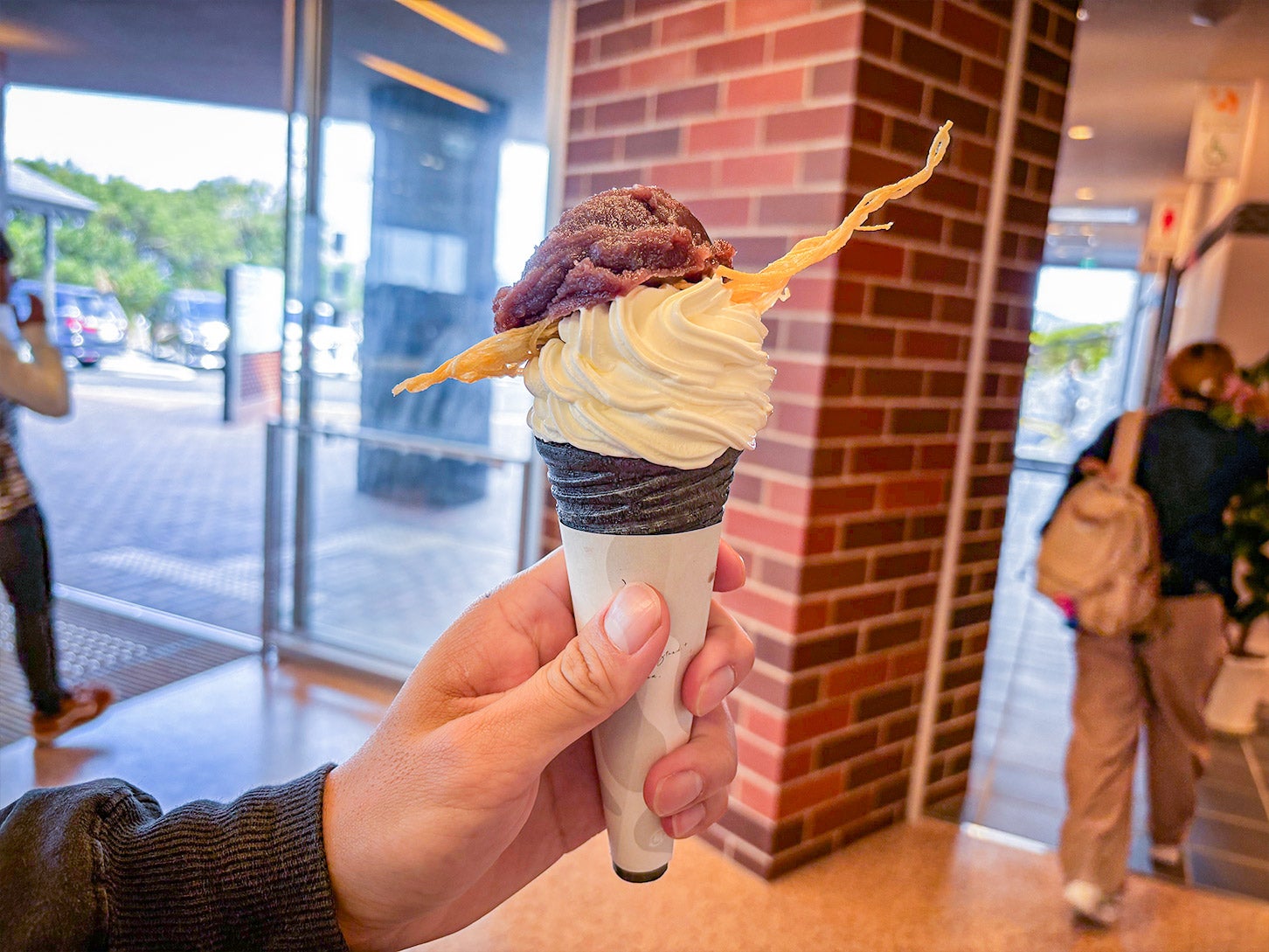 ミルクソフト専門店「あわじ島ミルクスタンド＋（プラス）」では、オリジナルソフトクリームを食べられます。こちらは、うず潮あんこがのった「This is あんバランス」（税込1000円）です。食べ方は、別添えのカップが渡されるので、そちらにソフトクリームごとドボンと入れて、スプーンで食べます。