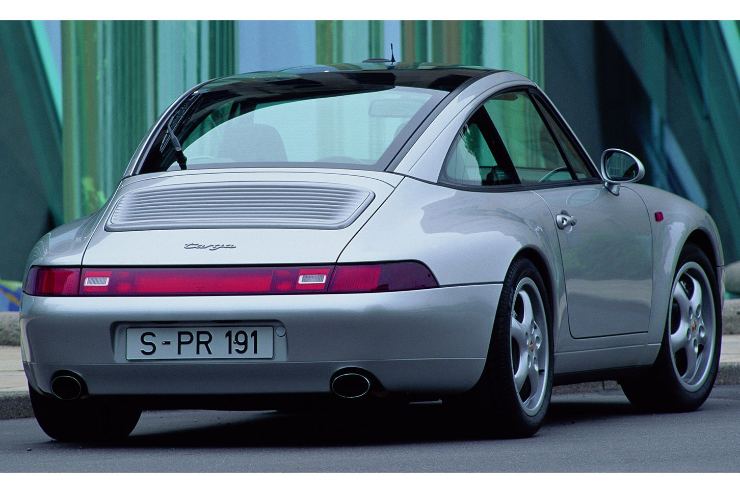 ポルシェ911タルガ3.6（993型／1996年モデル）｜1995年11月に発表された4代目993型からは幅広Bピラーが廃止。ルーフ部分には超大型の熱線吸収ガラスが採用されて、その大部分がスイッチひとつでリヤウインドウの内側に重ねて格納されるというワンタッチ式のオペレーションが可能となった。6気筒エンジンは3.6リッターの排気量により285psを引き出し、5.4秒の0-100km/h加速を実現。最高速は275km/hに届いた。