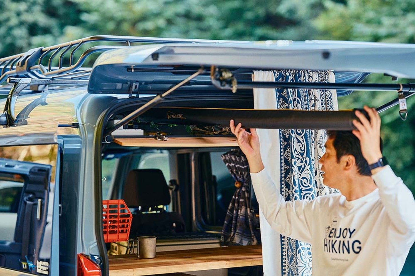 偶然にもロッドをバックドアから入れてルーフコンソールに差し込むとちょうど収納できたのだそう　「釣りもキャンプもDIYも、N-VANで広がった車中泊の達人のアウトドアライフ」から引用