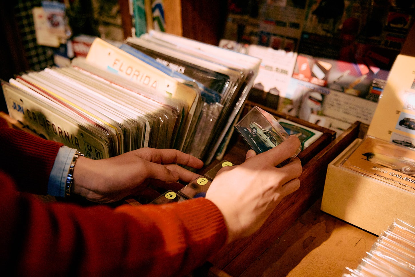 階段横のスペースにはクルマ関係の雑貨がキレイに並ぶ。ミニカーやカタログなども購入できたり