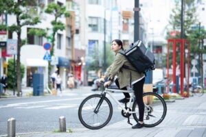 自転車で荷物を運ぶ女性。(c)west_photo – stock.adobe.com