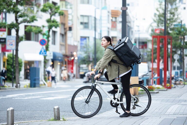 自転車で荷物を運ぶ女性。(c)west_photo – stock.adobe.com