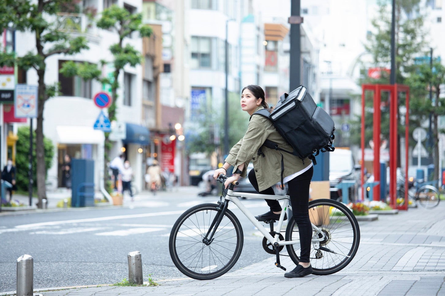 自転車で荷物を運ぶ女性。(c)west_photo – stock.adobe.com