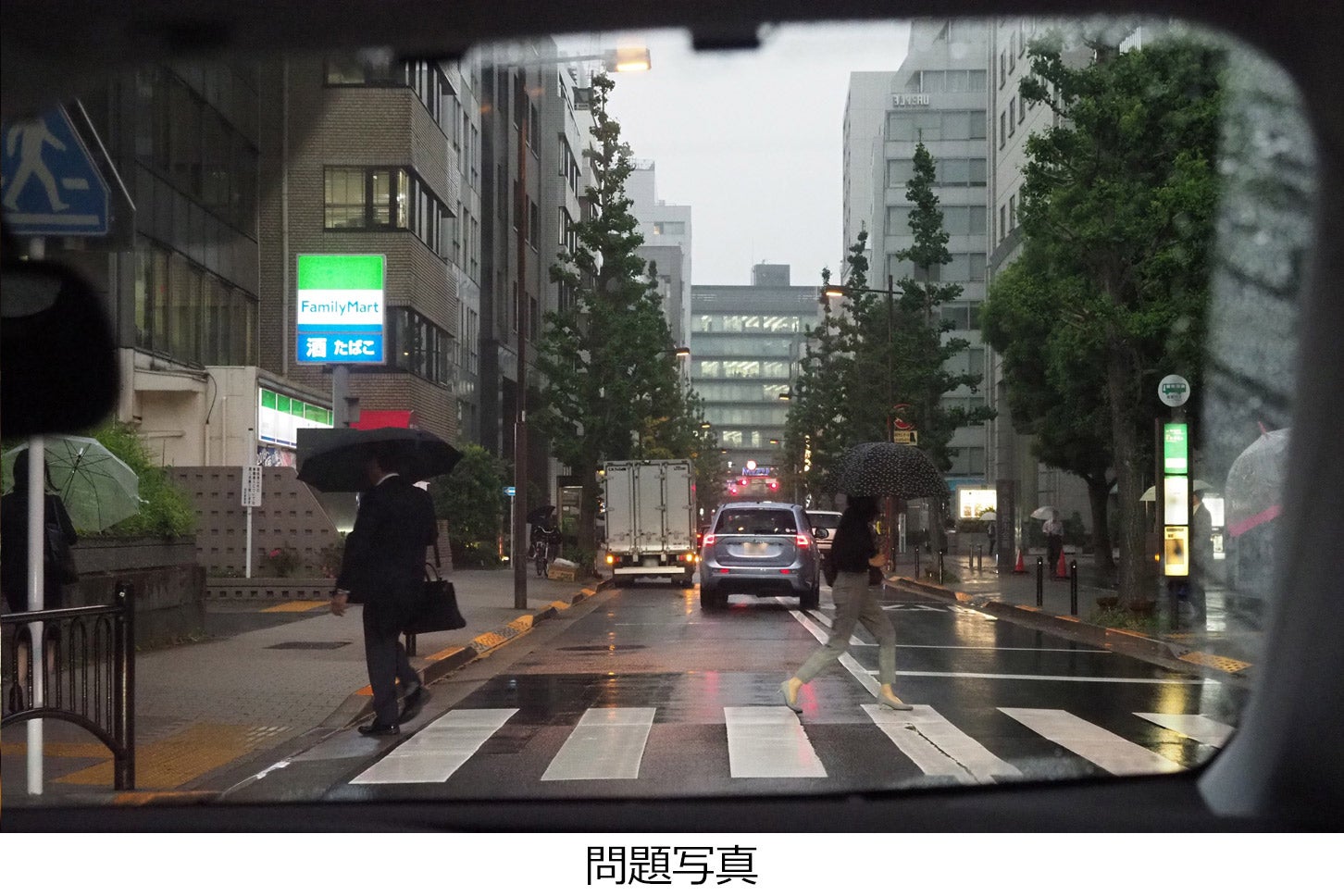 雨の降る夕方、横断歩道を通過しようとしています。