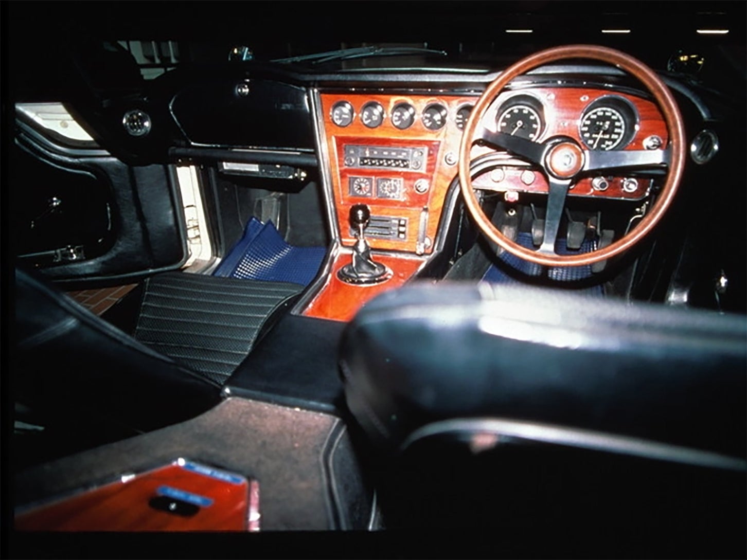 ローズウッドが飴色に輝くダッシュボード。その下部には、パーキングブレーキのレバーが設置されており、手前に引くとブレーキがかかる。