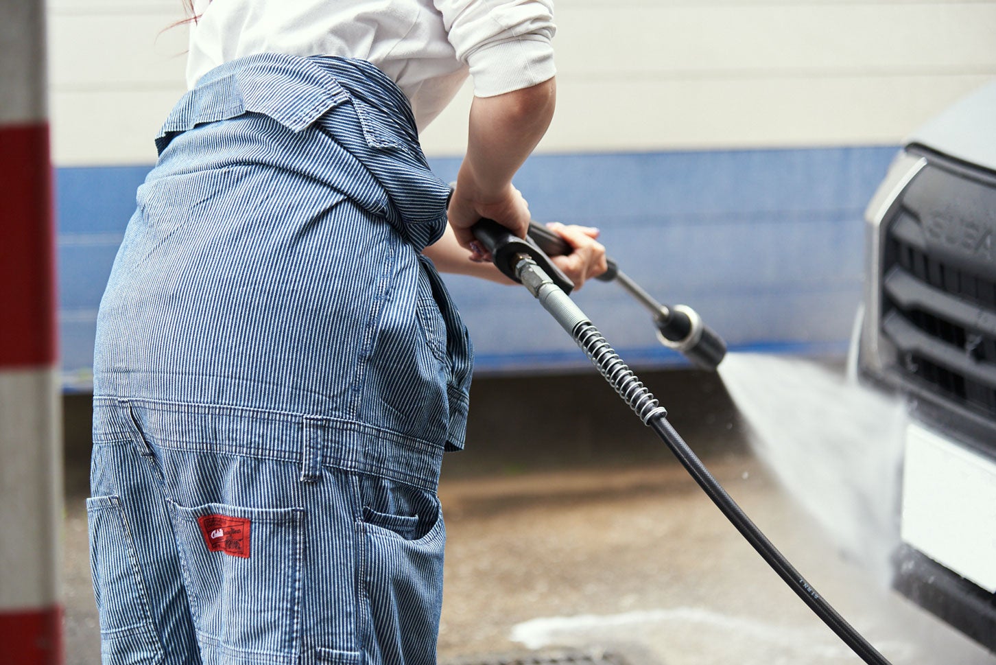 ヴィンテージテイスト溢れるヒッコリーストライプのつなぎ服。赤色のブランドタグがアクセントに。 ¥17,050 / AUTO-BI