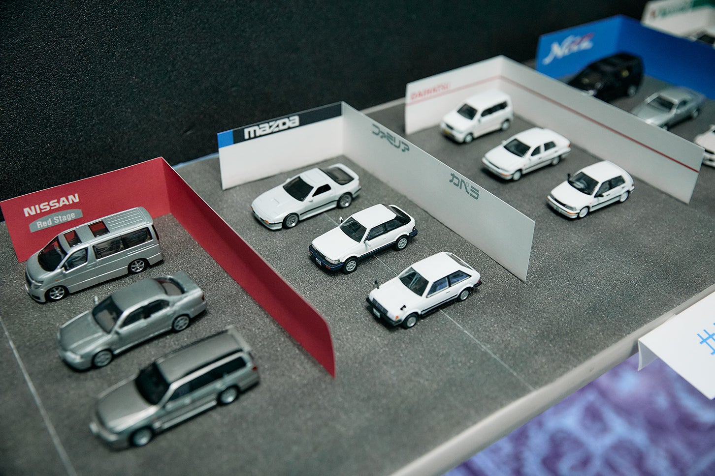 「1/64壁だけでクルマ屋シリーズ」を掲げるこちらのブースでは、自作のマニアックなミニカーに、自動車販売店を模した紙製の壁を組み合わせ、どこか懐かしい“街のクルマ屋”を再現。手軽ながら雰囲気たっぷりで、思わず真似したくなるジオラマ展示となっていた。