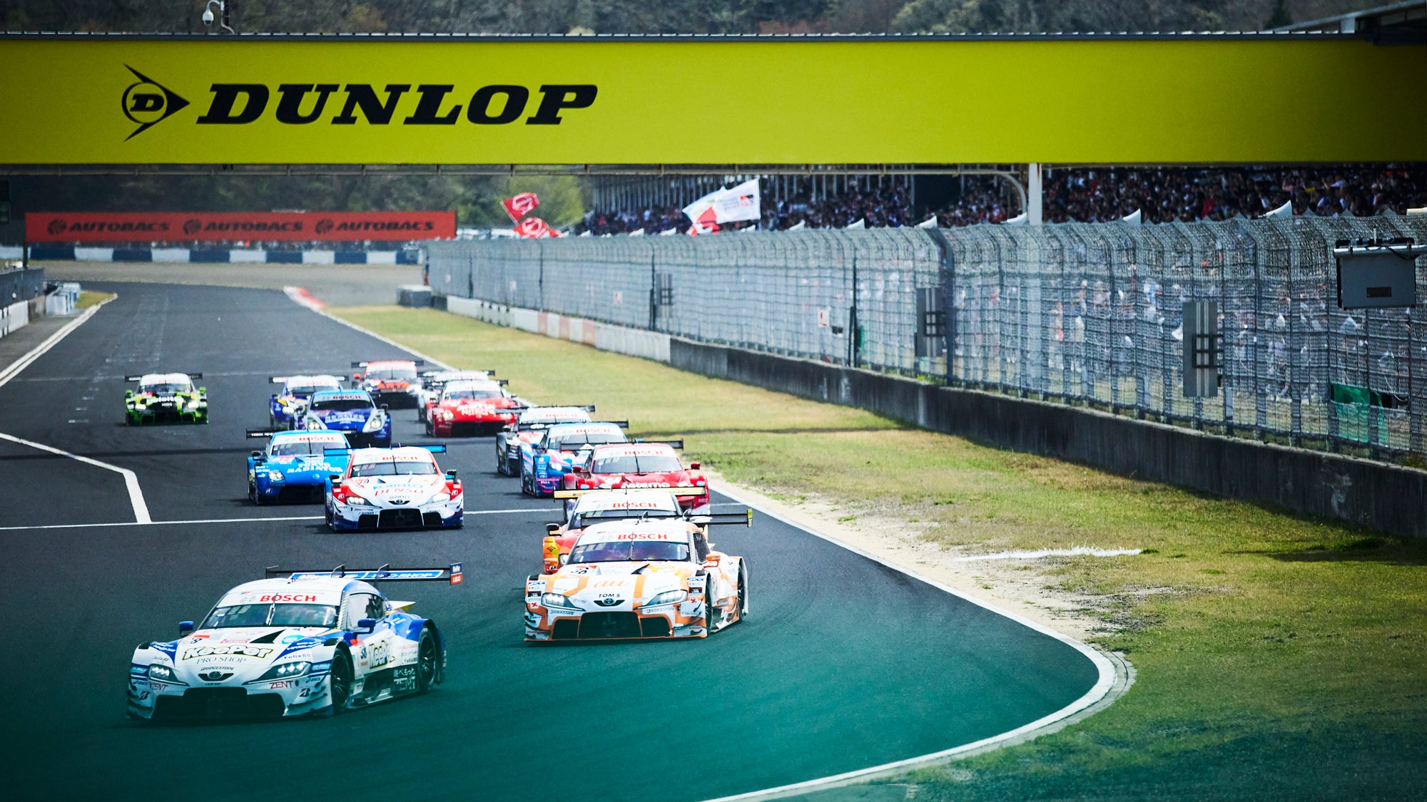 岡山国際サーキットで開催されたスーパーGT開幕戦の決勝レース。GT500はポールを獲得したKeePer CERUMO GR Supraが1コーナーをトップで駆け抜けていく。
