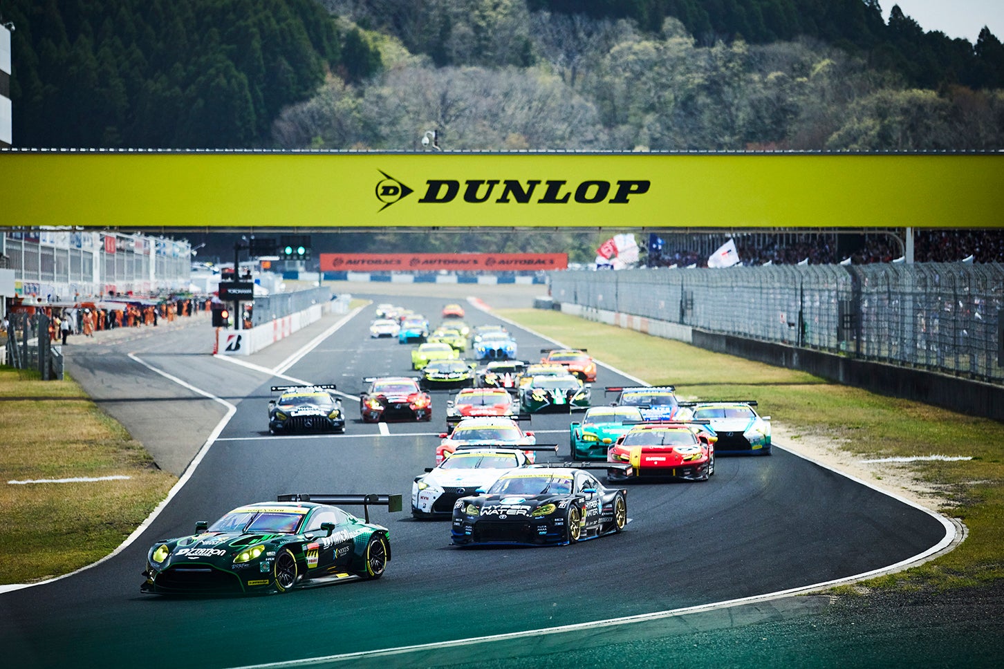 ローリングスタートから1コーナーへなだれ込むGT300クラスの29台の車両。3位表彰台を獲得する小山美姫がドライブする31号車、apr LC500h GTはこの時点ですでに3番手につけている。
