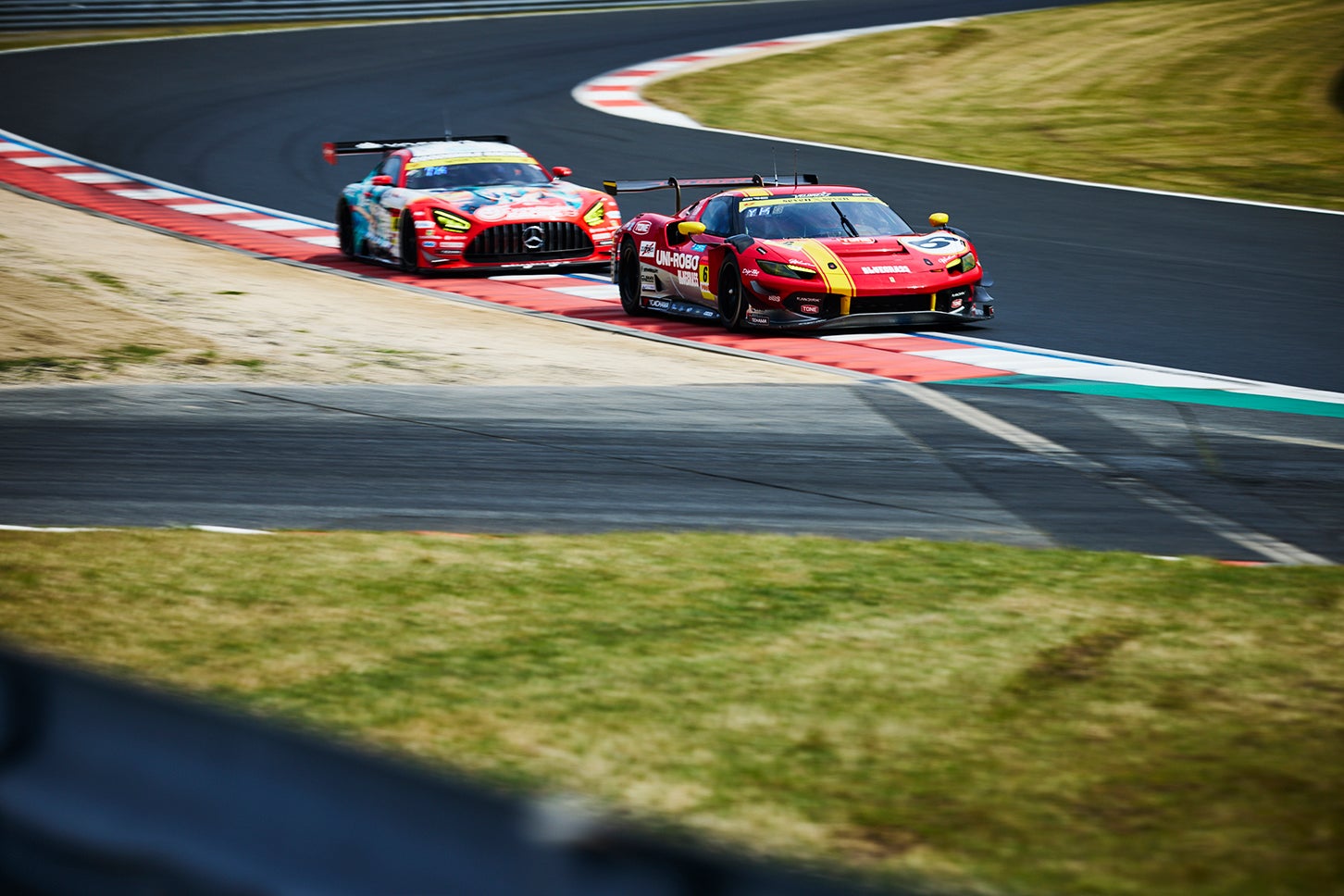 岡山国際をホームコースとしている6号車、UNI-ROBO BLUEGRASS FERRARIはチームのリードドライバー、片山義章と今年から加入したドイツ人ドライバー、ニクラス・クルッテンがステアリングを握る。直後に4号車、グッドスマイル初音ミクAMGが迫る。