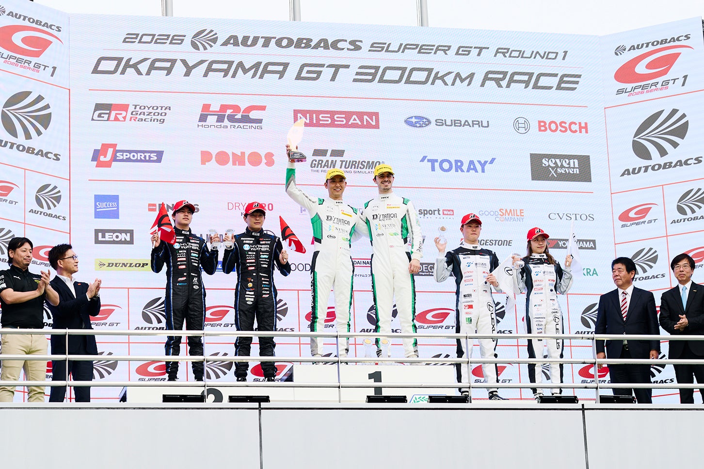 GT300表彰台。中央はD’ステーション・レーシングの藤井誠暢、チャーリー・ファグのコンビ。右には日本人女性ドライバーとして初表彰台を獲得したapr LC500hをドライブした小山美姫の姿もある。