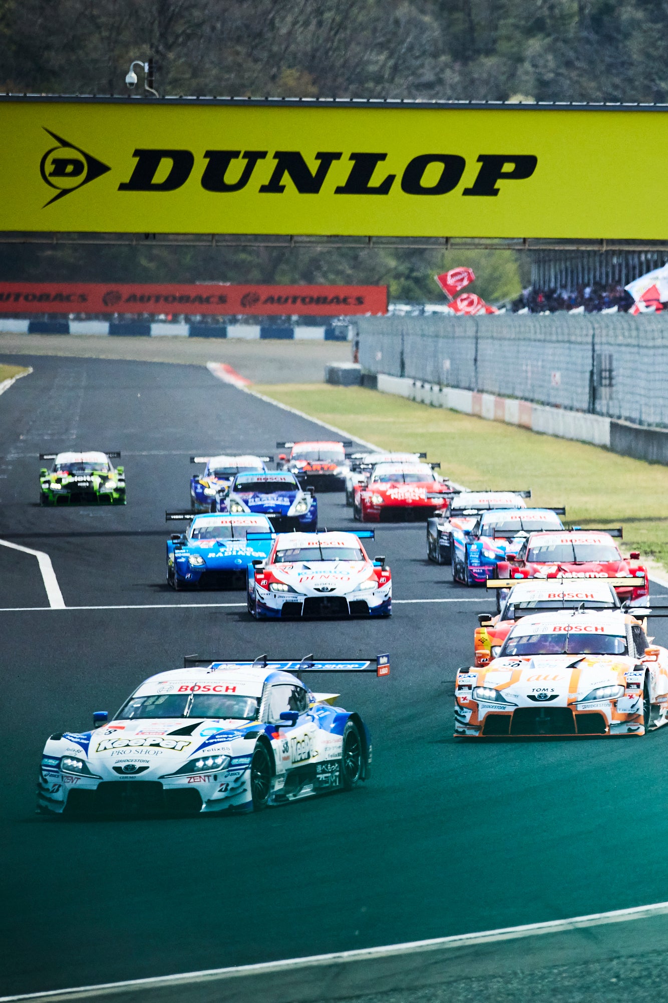 岡山国際サーキットで開催されたスーパーGT開幕戦の決勝レース。GT500はポールを獲得したKeePer CERUMO GR Supraが1コーナーをトップで駆け抜けていく。