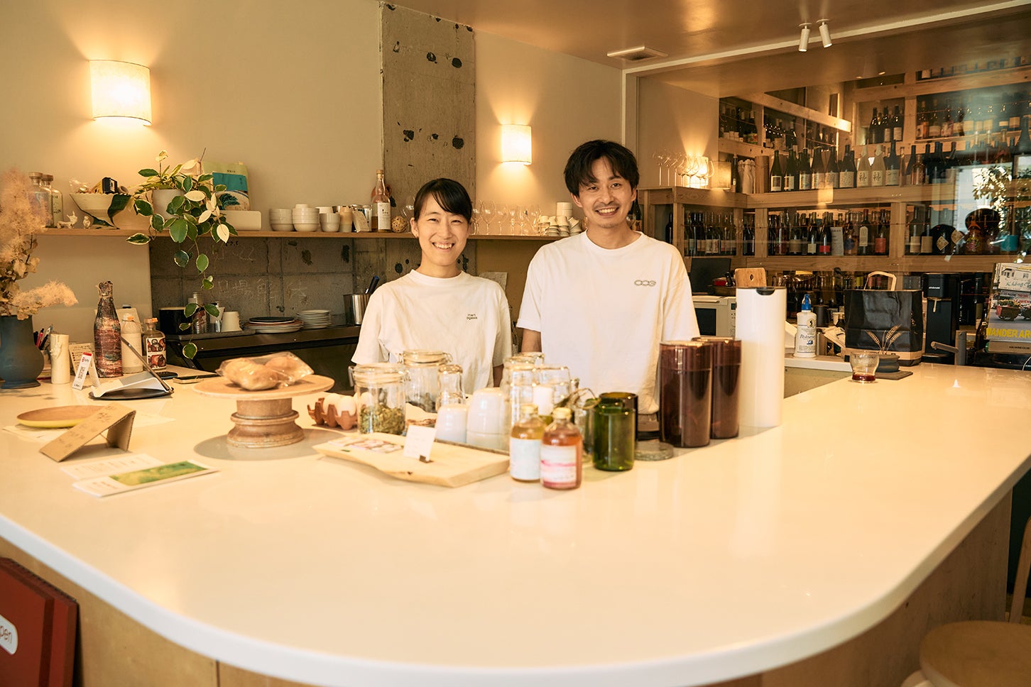 児林さんが経営する「mart.ogawa」で奥様と。カウンターの奥には、厳選されたワインがずらりと並ぶ。（写真＝佐藤大輝）