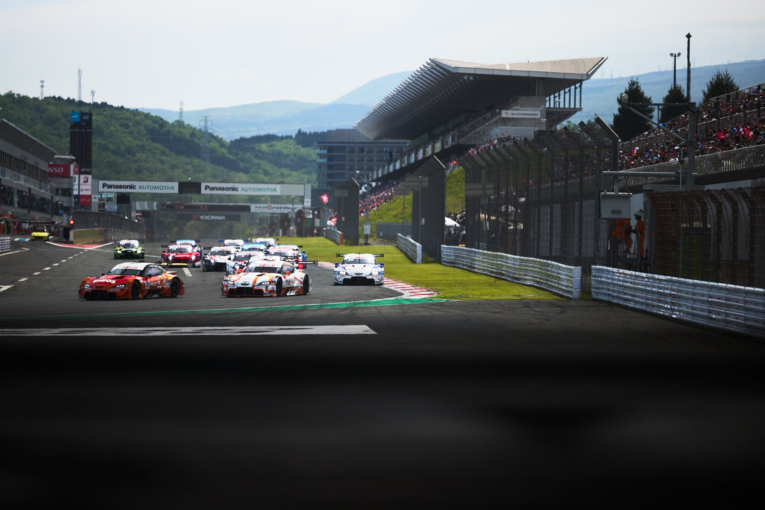 ローリングスタートで1コーナーへと進入していくGT500クラス。レースが3時間と長いこともあり、各車とも十分にクリアランスをとったスタートとなったようだ。夜に暴風雨が吹き荒れ、決勝は蒸し暑い天気となったが、多くの観客が富士を訪れ、レースを見守った。