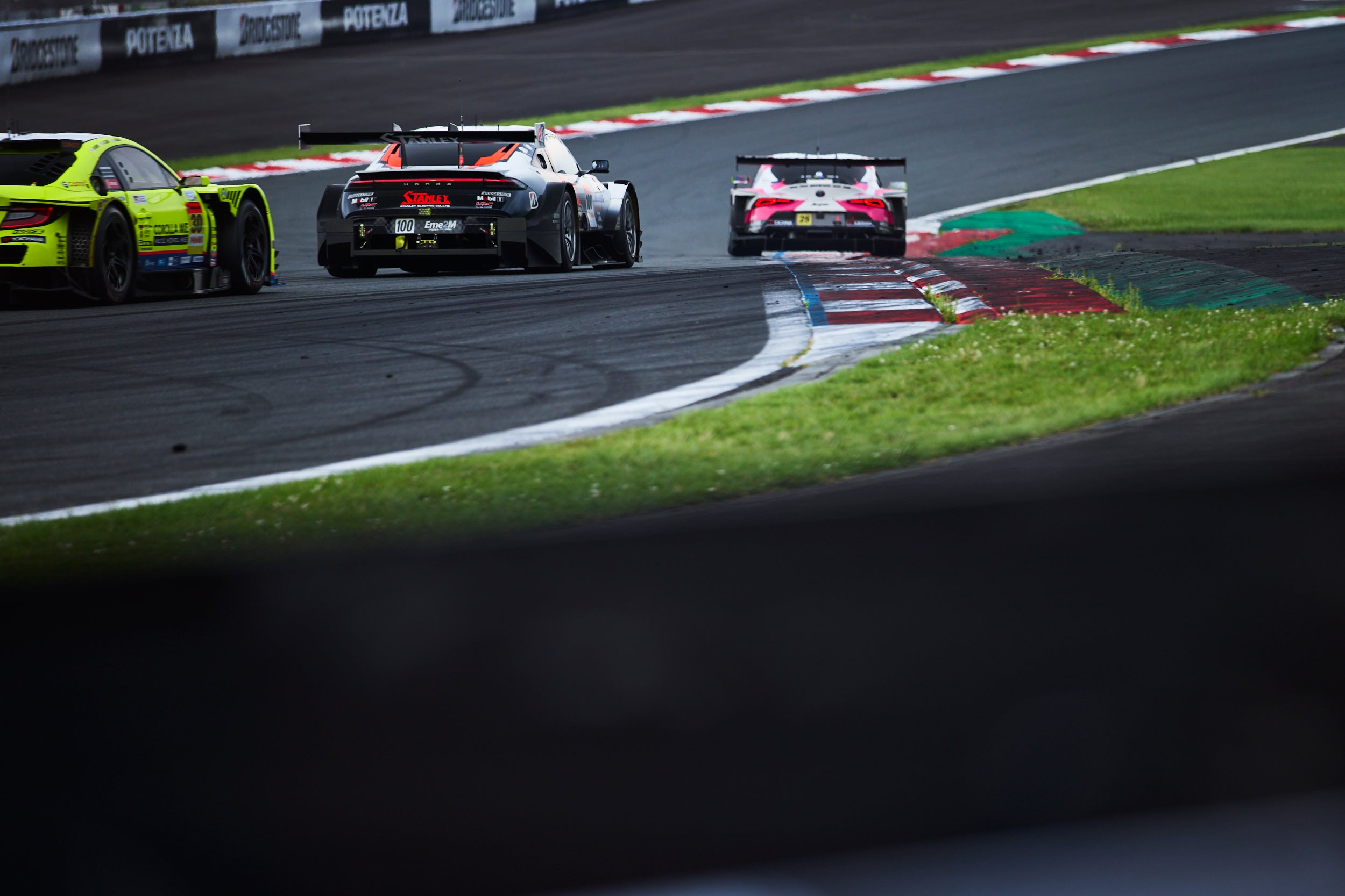 タイトなコーナーが続くセクター3で、GT300クラスのマシーンに挟まれながら走行する#100 STANLEY HRC PRELUDE-GT。レース終盤、牧野任祐は#8を駆る太田格之進に差を詰められるが、冷静に走り切り、コンマ6秒差で優勝を果たした。