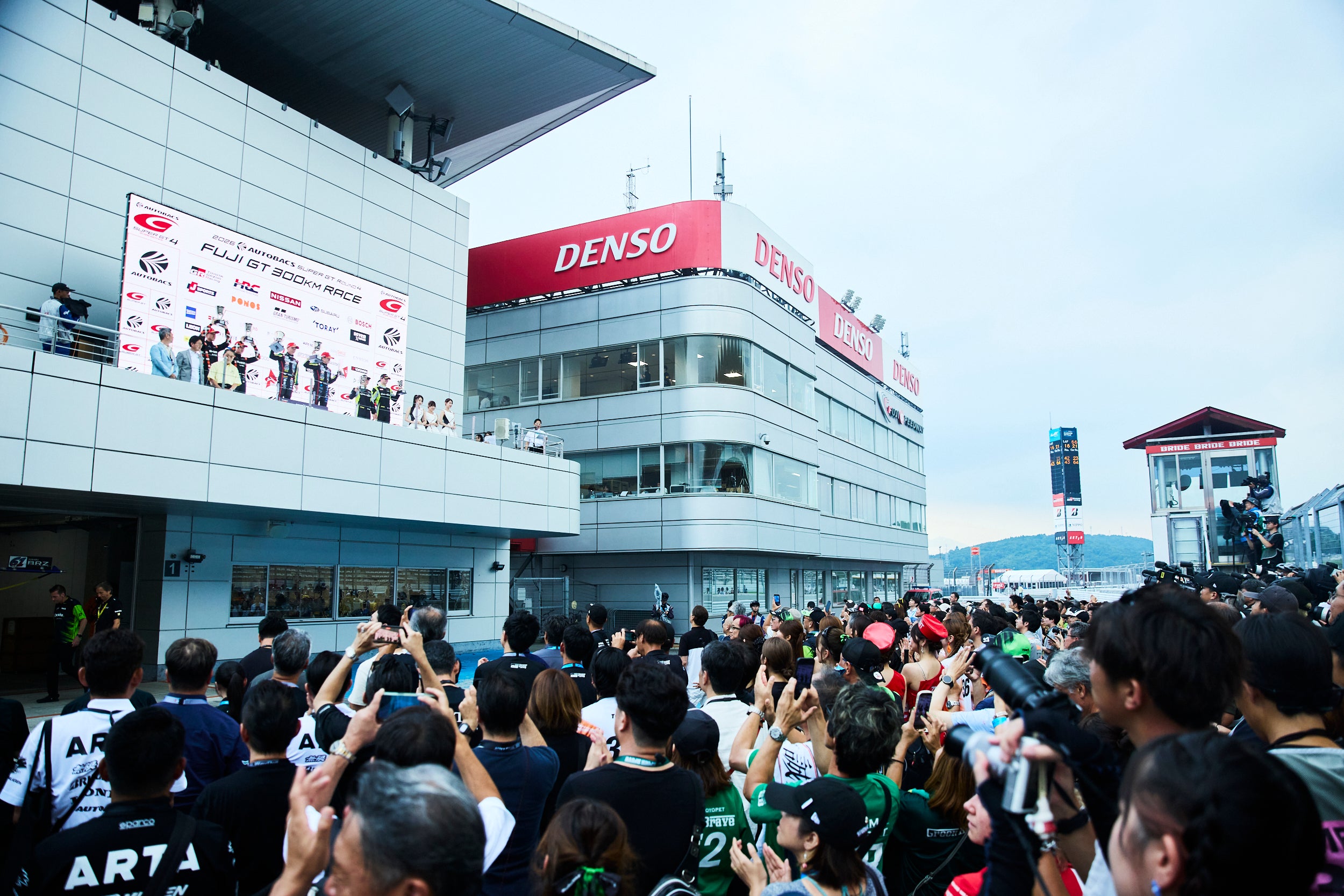 夕暮れが迫り、少し涼しくなったFSW。表彰台の下は大賑わい。レース内容がよかっただけに、チームの側も観客も大いに盛り上がっていた。