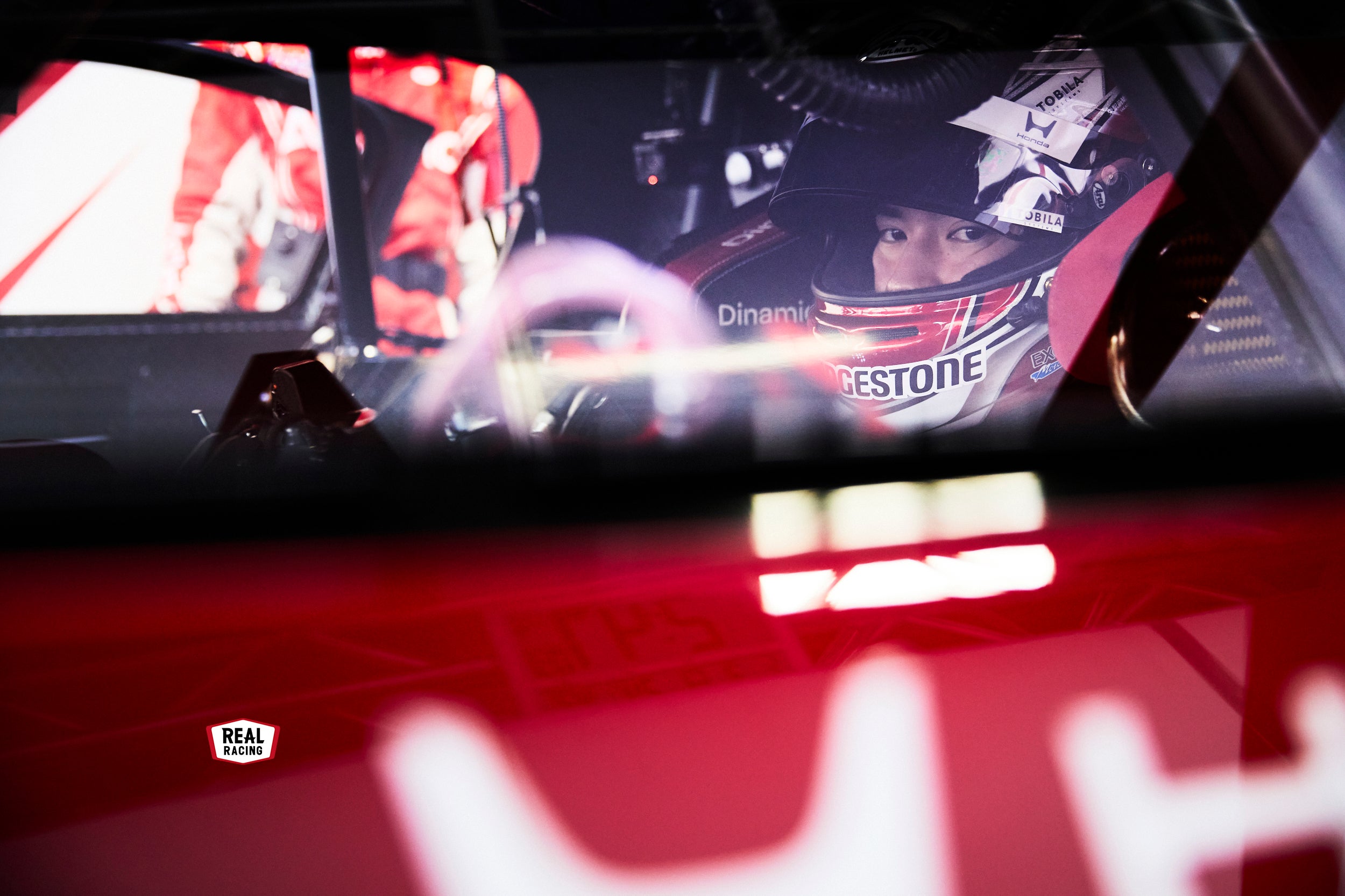 コクピットに収まり、出走を待つ野村選手。GTマシーンはカーボン製のモノコックシェルを持っており、ドライバーは一般的なクルマよりも後ろの位置に座っている。