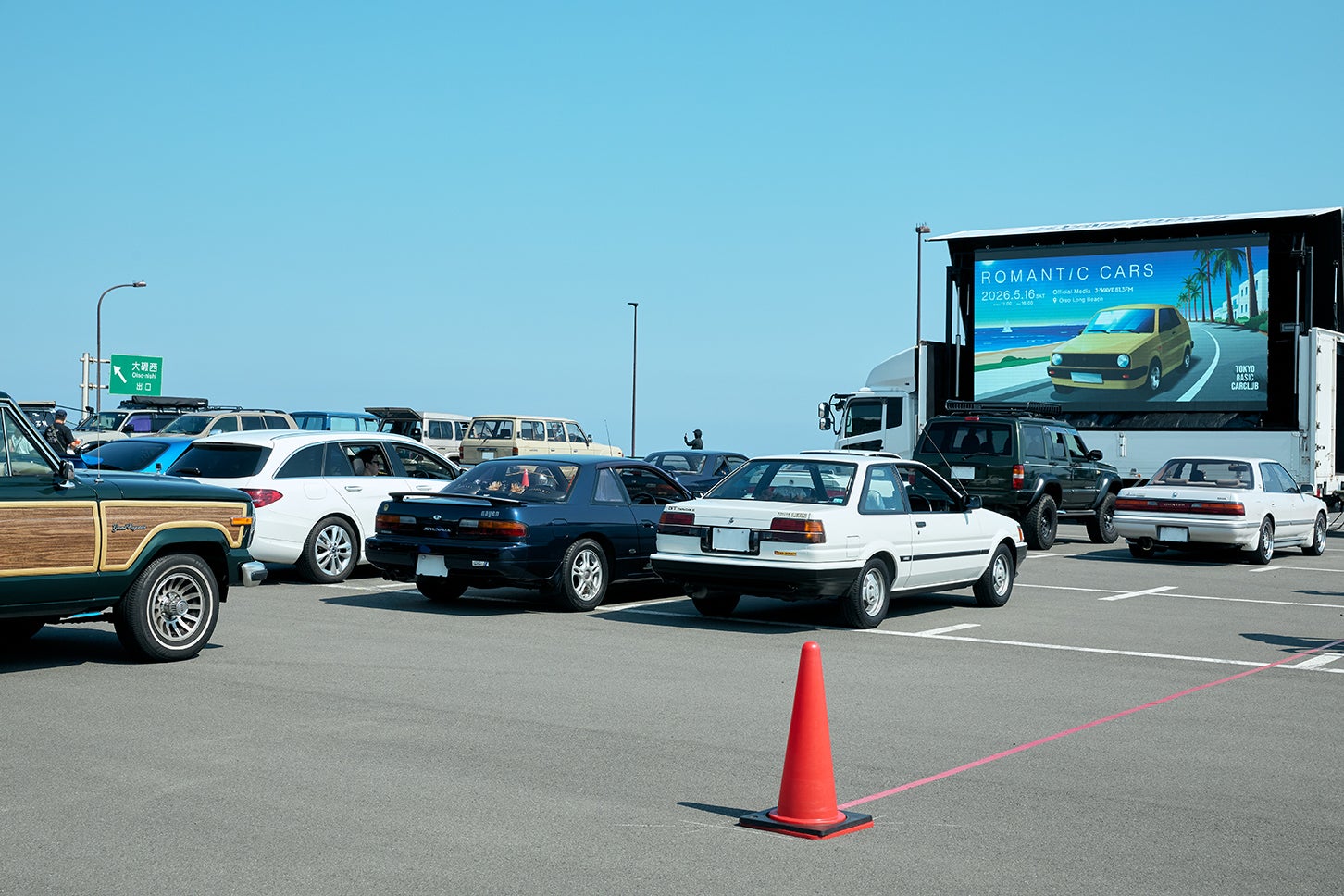 大型スクリーンでショートムービーを堪能。どこまでも広がる青空と海、そして隣には恋人や友人。愛車と過ごす、これ以上ない最高の時間だ。