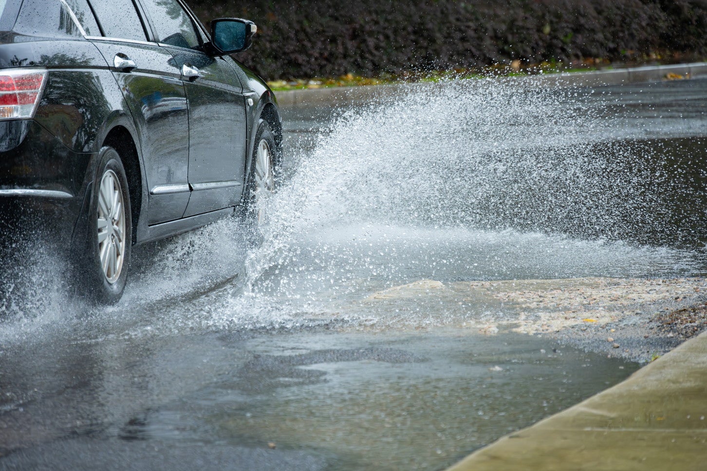 水たまりを走行するクルマ。(c)Freer – stock.adobe.com
