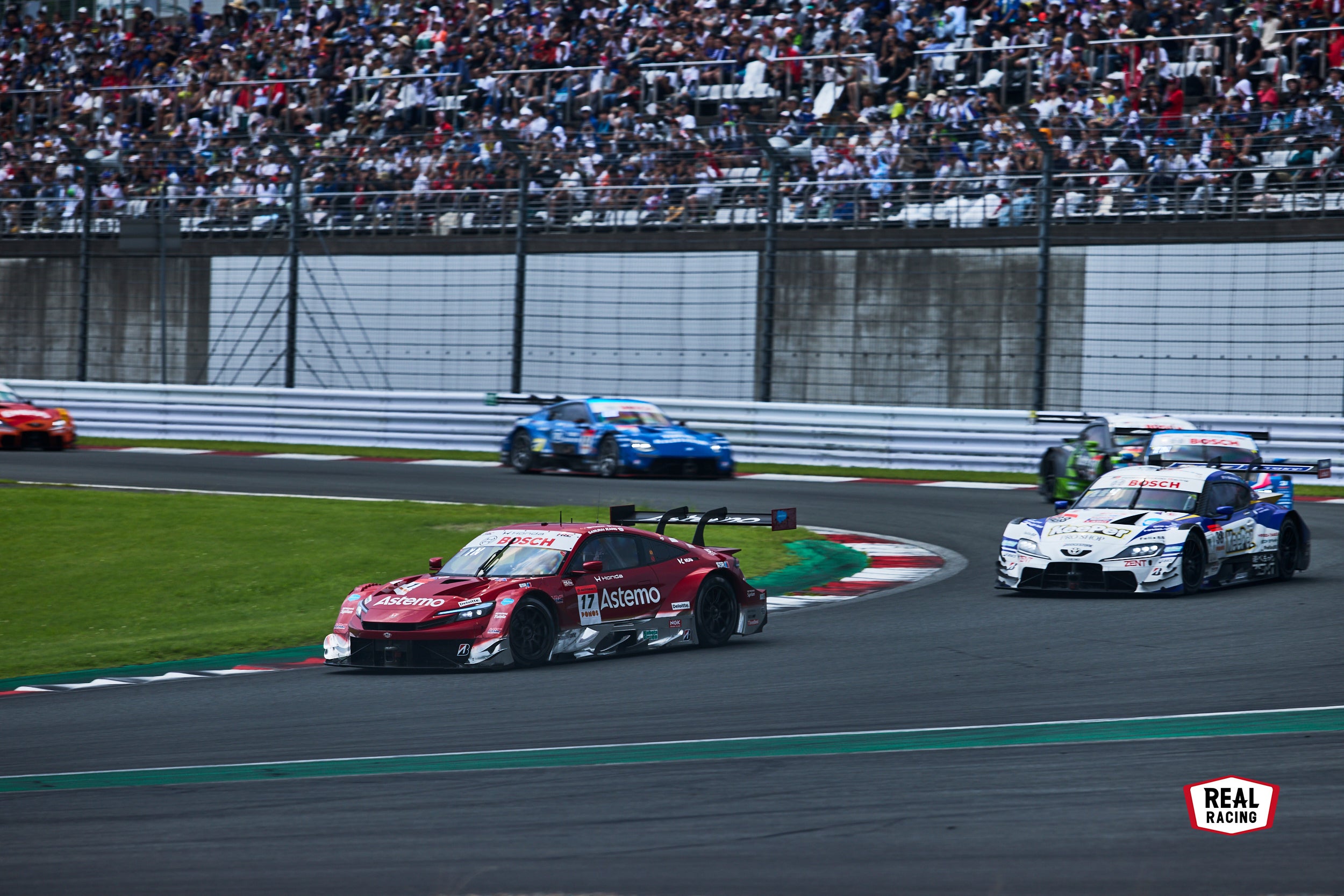 300km/h近い最高速からのブレーキングが見られる富士スピードウェイの1コーナー。グランドスタンドは、熱心な観客にとって人気の観戦スポットでもある。