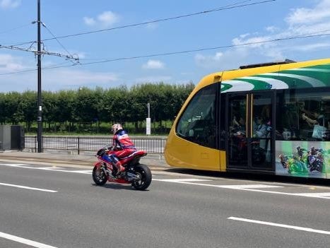 宇都宮LRTラッピング車両と並走する中上貴晶選手