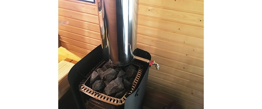 サウナストーブの今のトレンドは薪式。この下にあるストーブで火を焚くことで、サウナストーンと温水タンクの水を温めることができる。