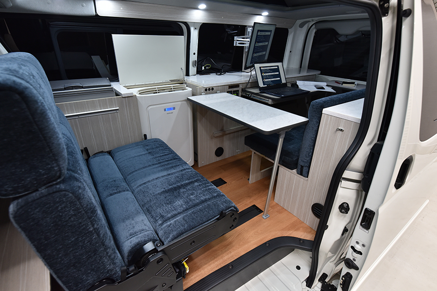 車内にはオフィス用のデスクやシート、冷蔵庫も完備。セカンドシートレイアウトは前向き、後ろ向き、フラットと状況に合わせて３つの展開が可能で、車中泊のベッドとしても利用できる。
