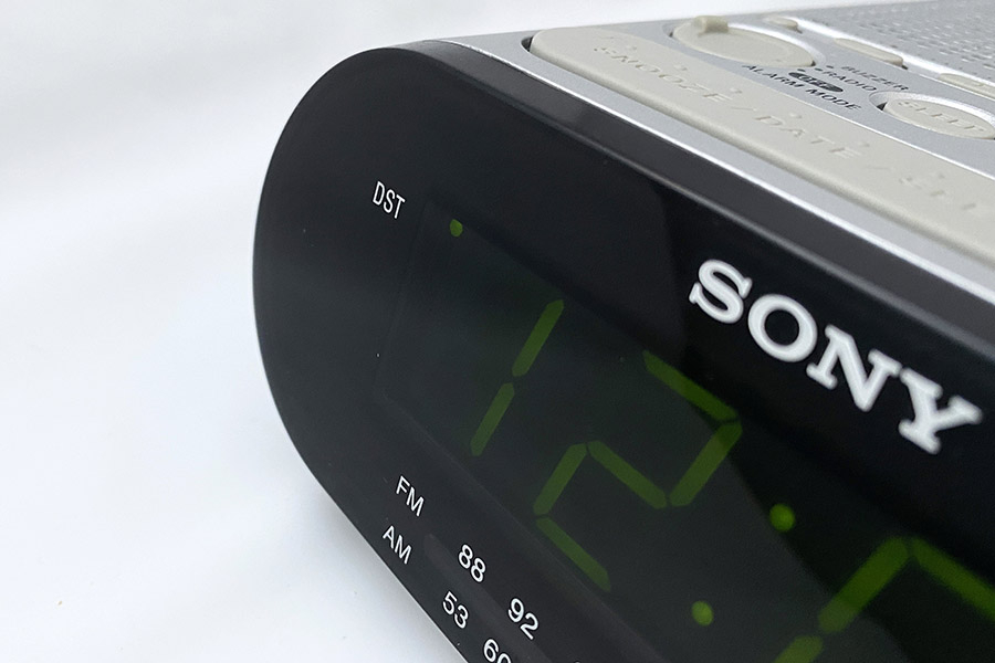 我が家のラジオ付きデジタル時計。DST（夏時間）スイッチを押すと、ディスプレイ内に緑のドットが灯る。
