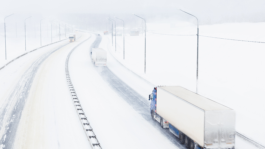 大雪の道路を走るトラック
