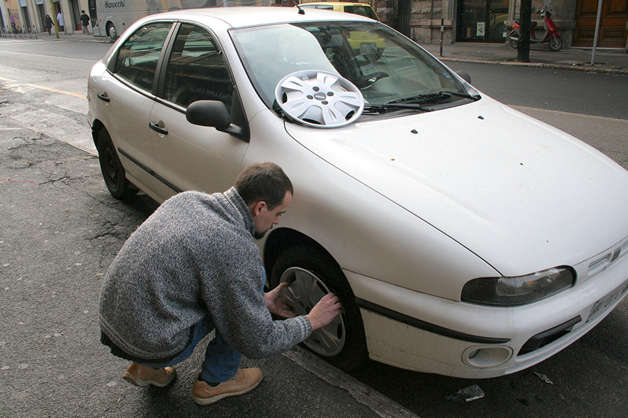 ホイールカバーを盗まれた愛車フィアット・ブラーヴァに、カー用品店のスタッフが新品を嵌めてくれているところ。2005年撮影。